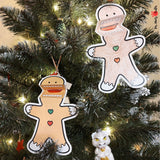 Two gingerbread man puppet crafts with movable mouths, one colored and one for coloring, showcasing bow ties and buttons, ready for creative play.