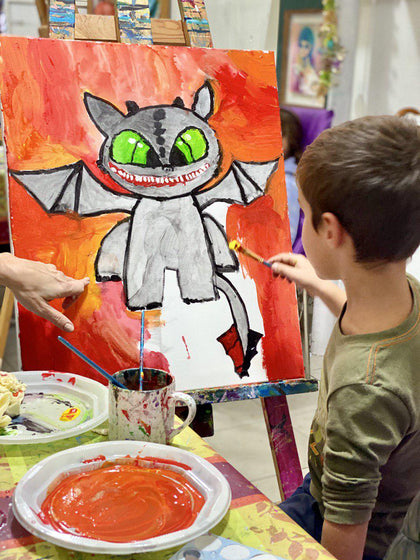 Boy painting a dragon with bright colors on canvas using brushes and paints — creative art and craft supplies from Mr. Mintz for kids’ DIY projects, drawing, and school crafts.