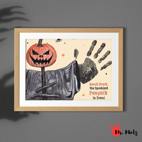 Spooky Halloween pumpkin handprint craft for kids featuring a jack-o’-lantern scarecrow and a black handprint, perfect for DIY decoration.